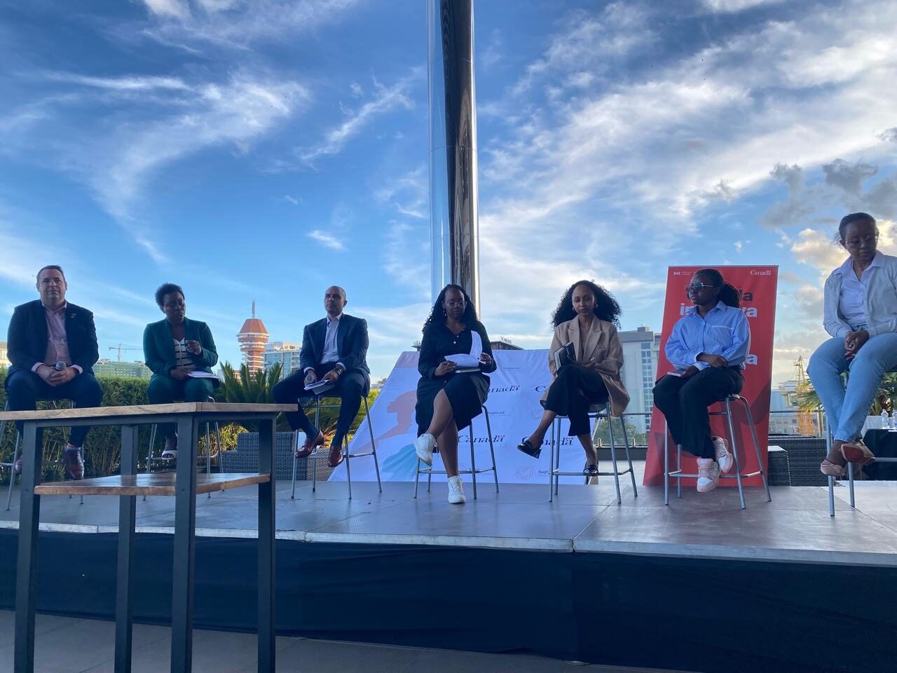 A strategic conversation on a Nairobi rooftop, city skyline in the background